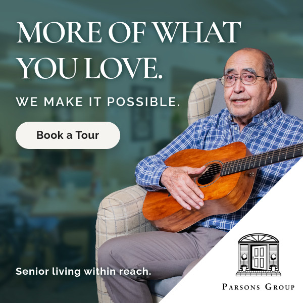 Advertisement for Parsons Group senior living: an elderly man sits in a chair with a guitar, smiling, with bold slogan 'MORE OF WHAT YOU LOVE. WE MAKE IT POSSIBLE.' A rounded 'Book a Tour' button sits left, and a white diagonal panel with the Parsons Group logo appears bottom right; caption 'Senior living within reach.'