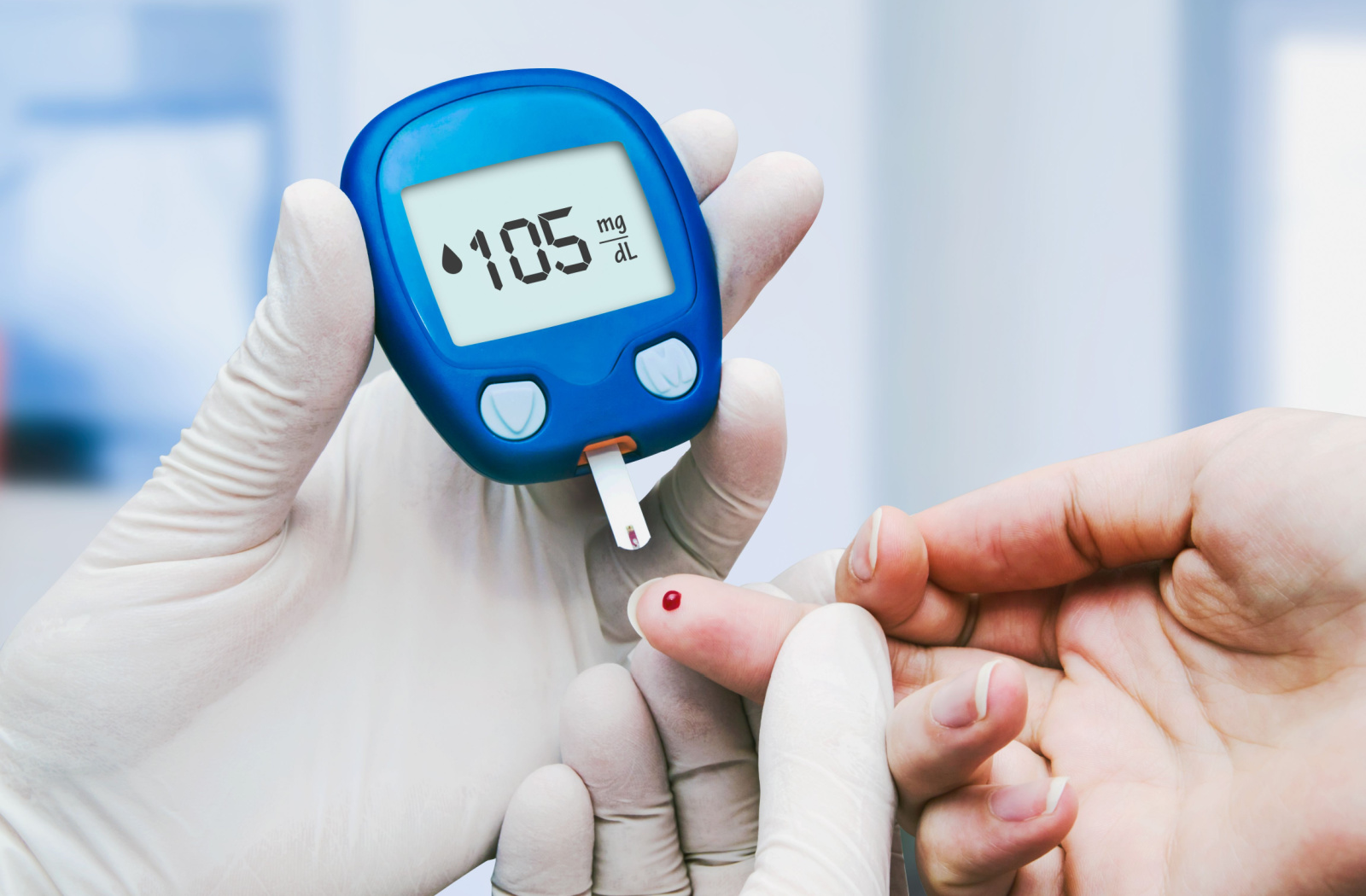 A doctor making blood sugar tests in the clinic for diabetes.