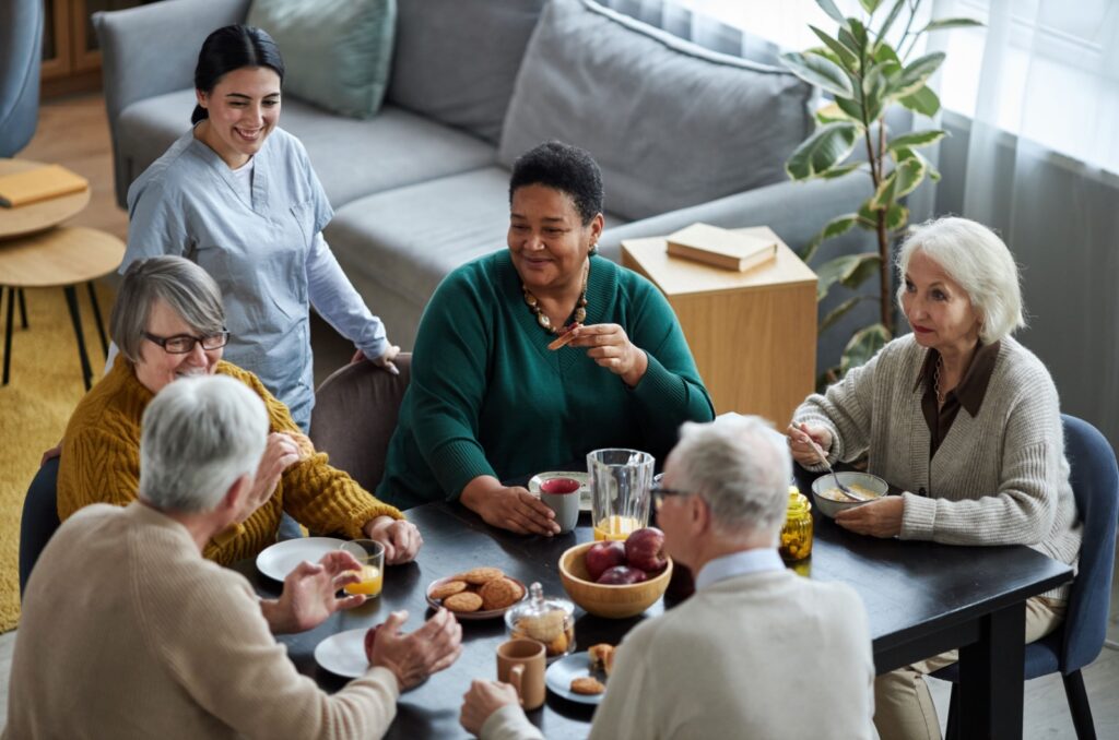 A top view of a group of happy older adults enjoying breakfast in assisted living.