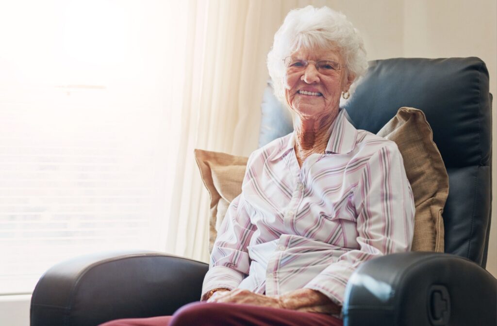 Smiling senior woman relaxing comfortably in a chair embodying the ease and independence of assisted living.