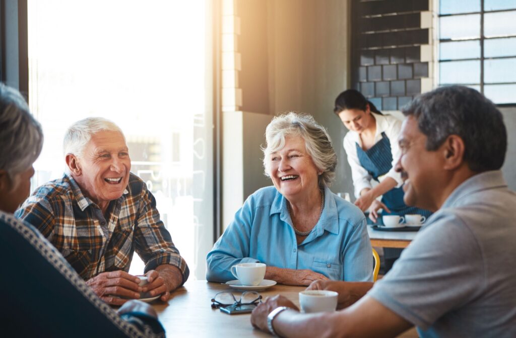 A group of senior friends share conversation and coffee in a relaxing cafe.