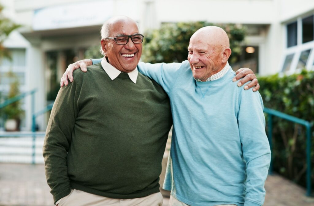 A pair of senior friends walking together with their arms around each other, enjoying a beautiful day.